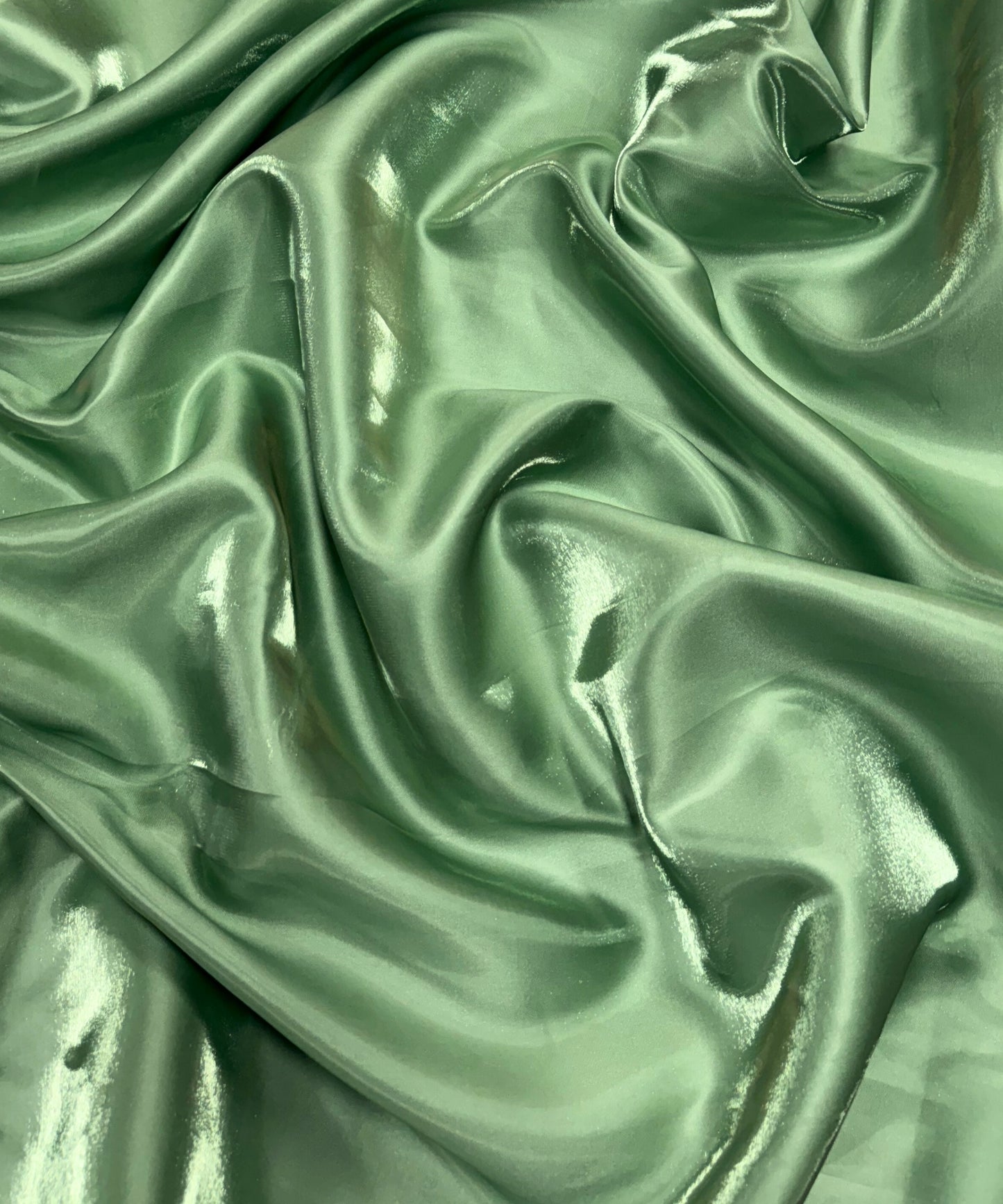 Sage green liquid bridal satin fabric with ultra-glossy finish, fluid drape, and silky smooth texture – perfect for gowns and elegant décor.