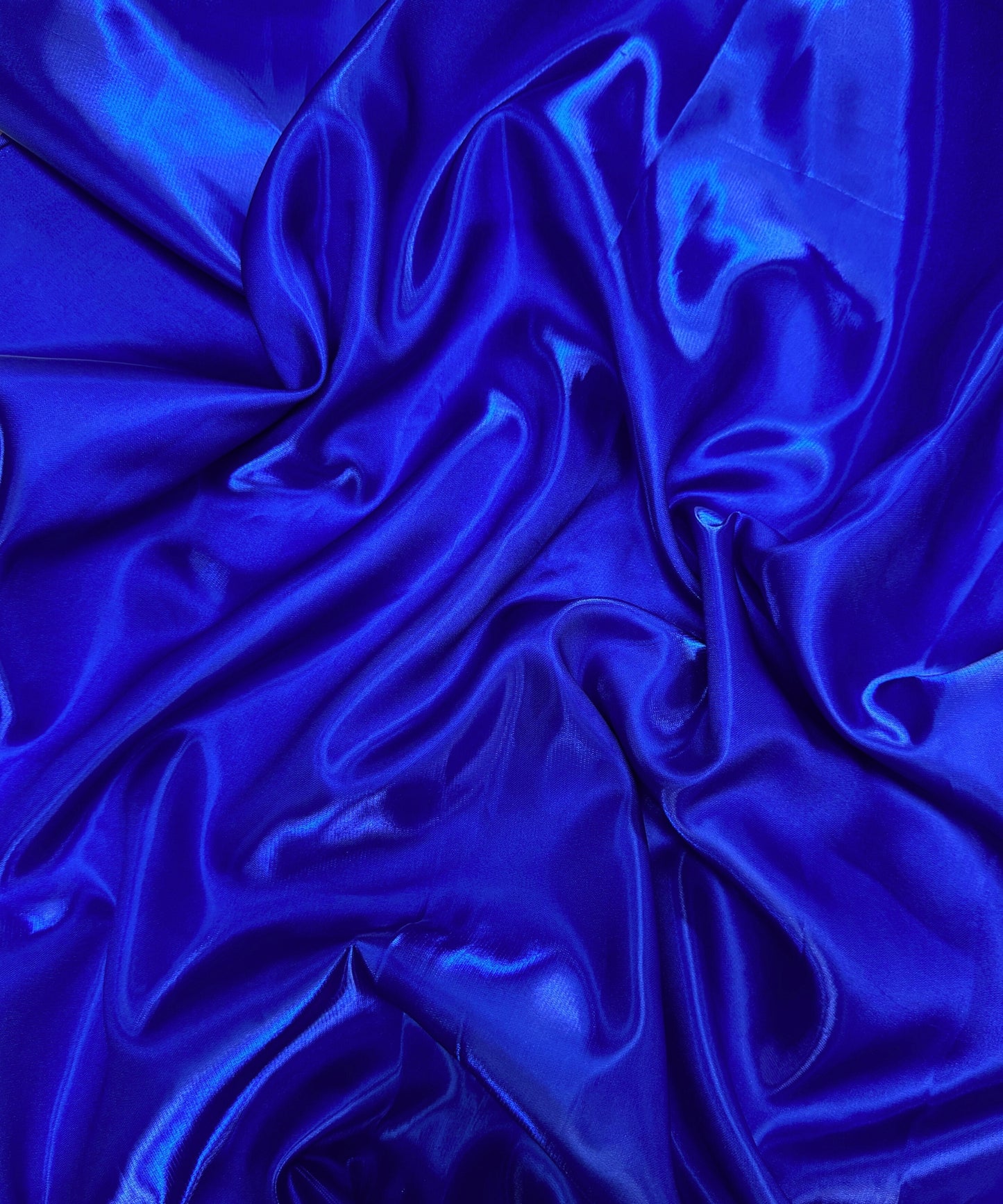 Royal blue liquid bridal satin fabric with ultra-glossy finish, fluid drape, and silky smooth texture – perfect for gowns and elegant décor.