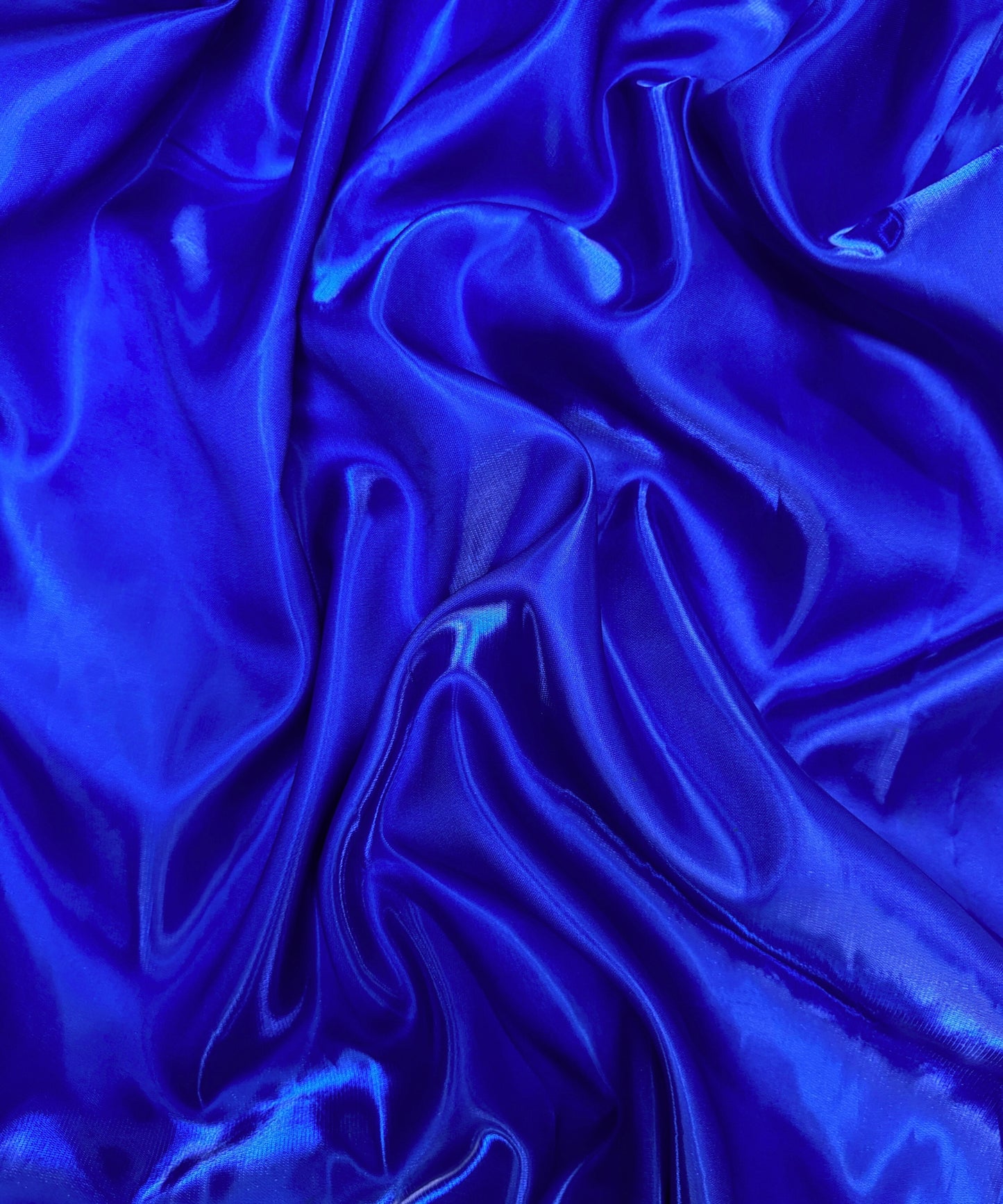 Royal blue liquid bridal satin fabric with ultra-glossy finish, fluid drape, and silky smooth texture – perfect for gowns and elegant décor.