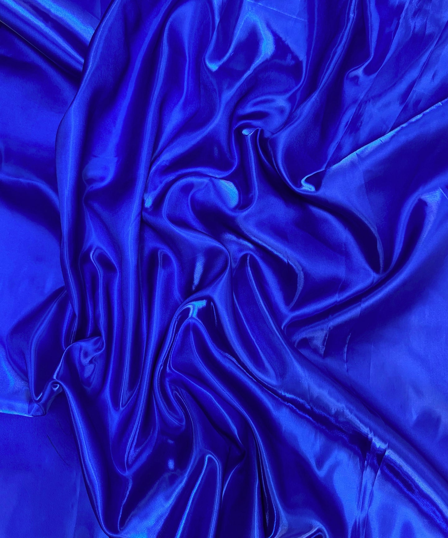 Royal blue liquid bridal satin fabric with ultra-glossy finish, fluid drape, and silky smooth texture – perfect for gowns and elegant décor.