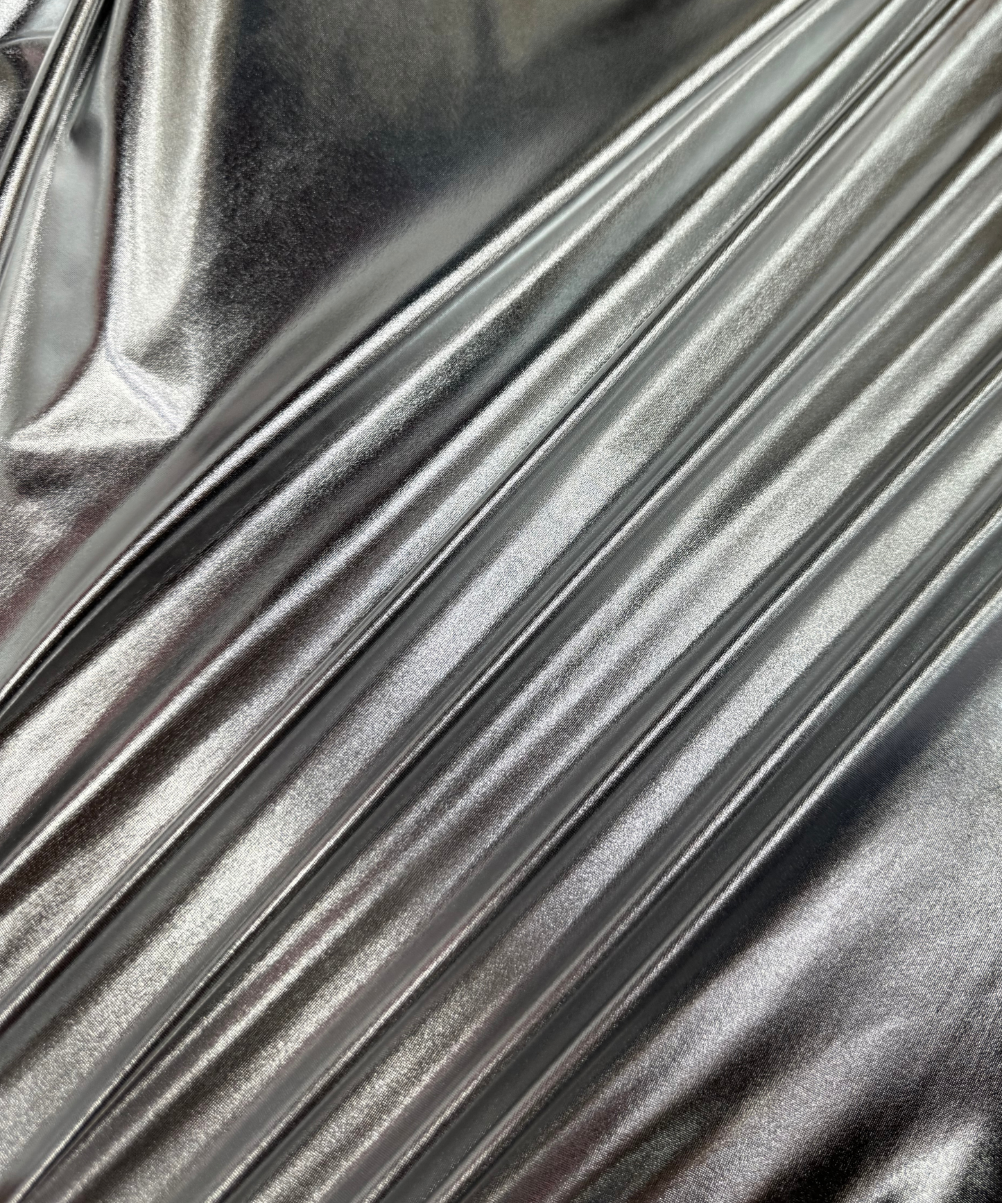 Close-up of metallic silver fabric. Silver Metallic Stretch Foil Lame fabric