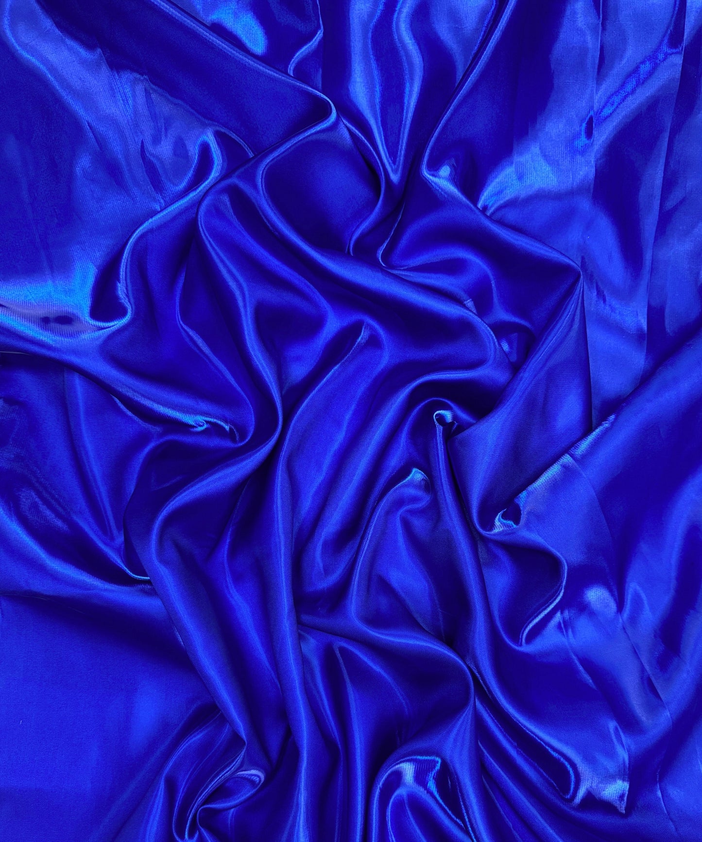 Royal blue liquid bridal satin fabric with ultra-glossy finish, fluid drape, and silky smooth texture – perfect for gowns and elegant décor.