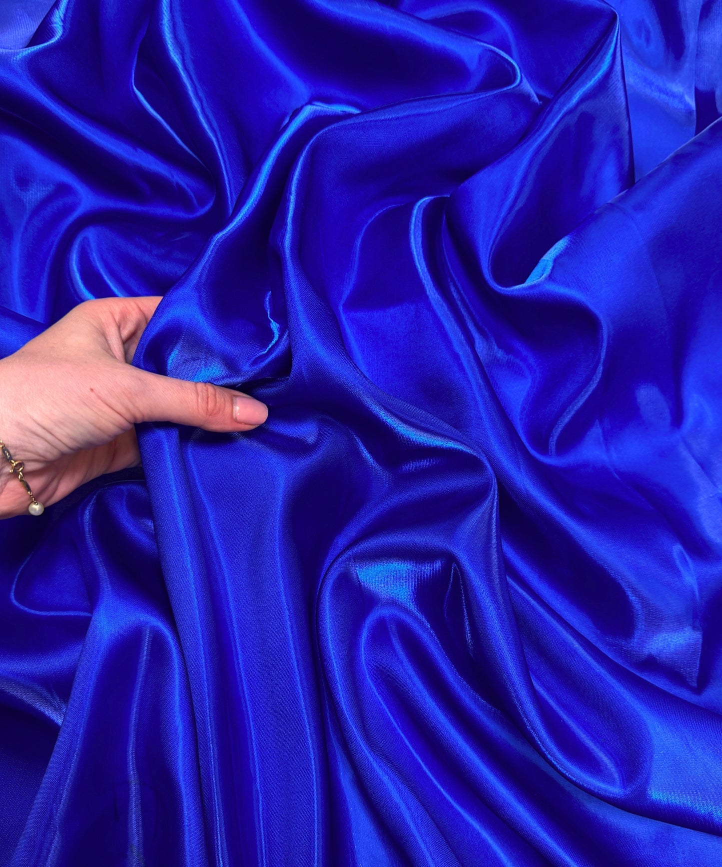 Royal blue liquid bridal satin fabric with ultra-glossy finish, fluid drape, and silky smooth texture – perfect for gowns and elegant décor.