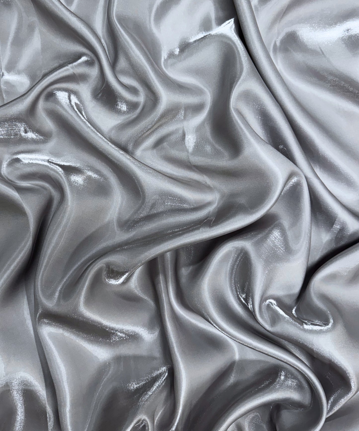 Silver liquid bridal satin fabric with ultra-glossy finish, fluid drape, and silky smooth texture – perfect for gowns and elegant décor.