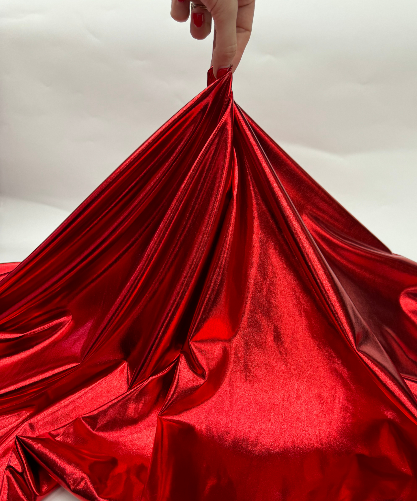 Close-up of metallic red fabric. Red Metallic Stretch Foil Lame fabric