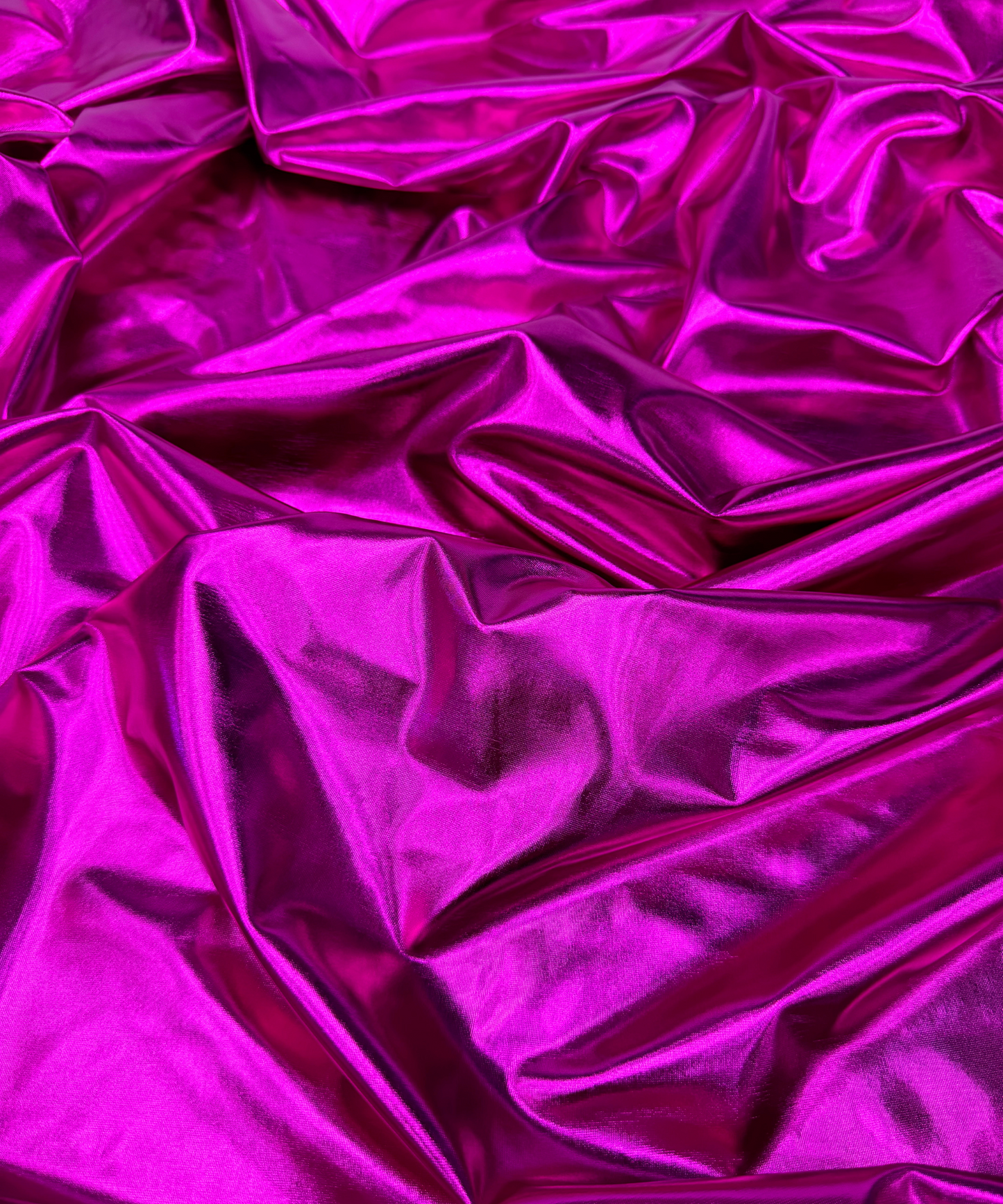 Close-up of metallic Fuchsia fabric. Fuchsia Metallic Stretch Foil Lame fabric