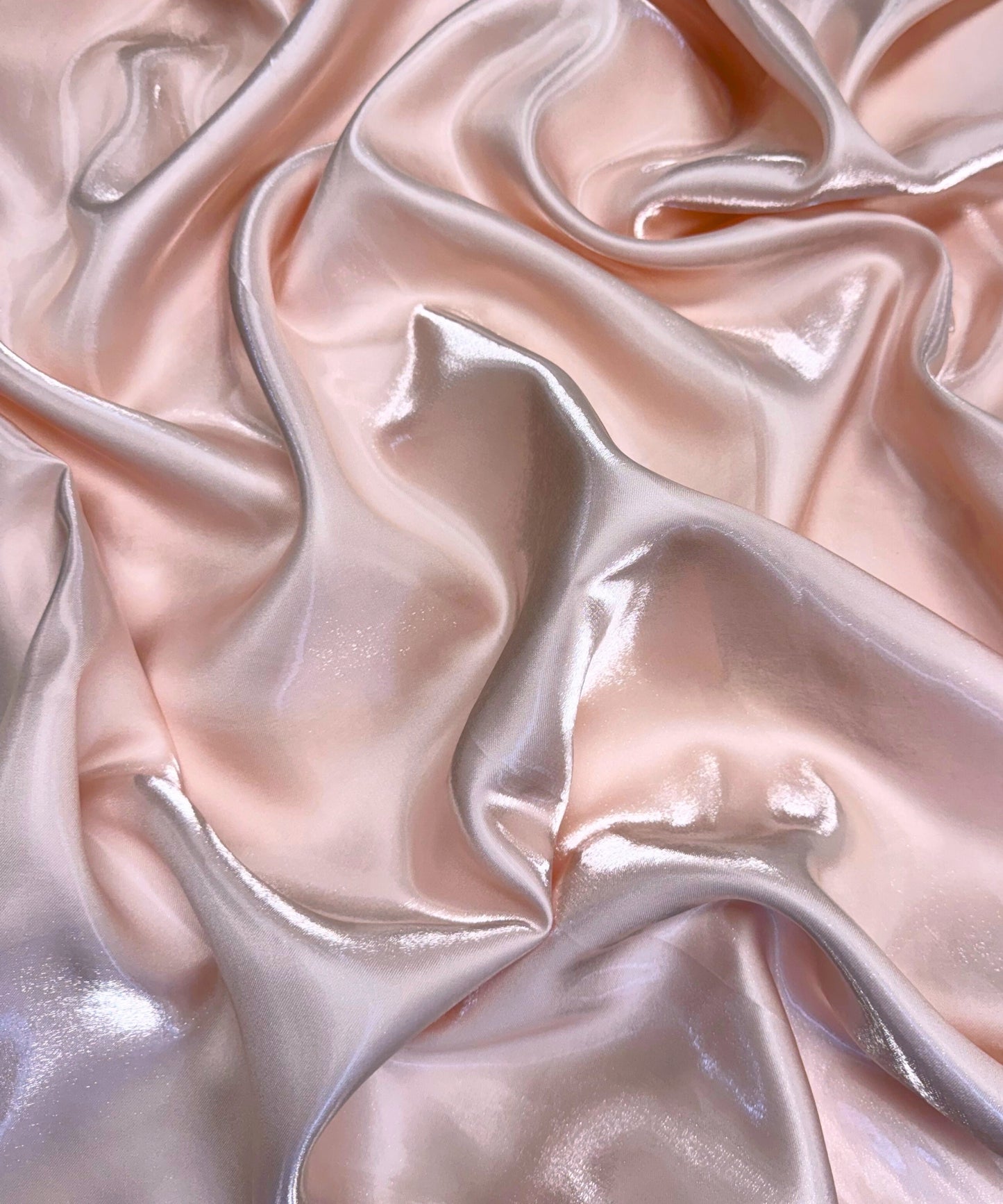 Blush liquid bridal satin fabric with ultra-glossy finish, fluid drape, and silky smooth texture – perfect for gowns and elegant décor.