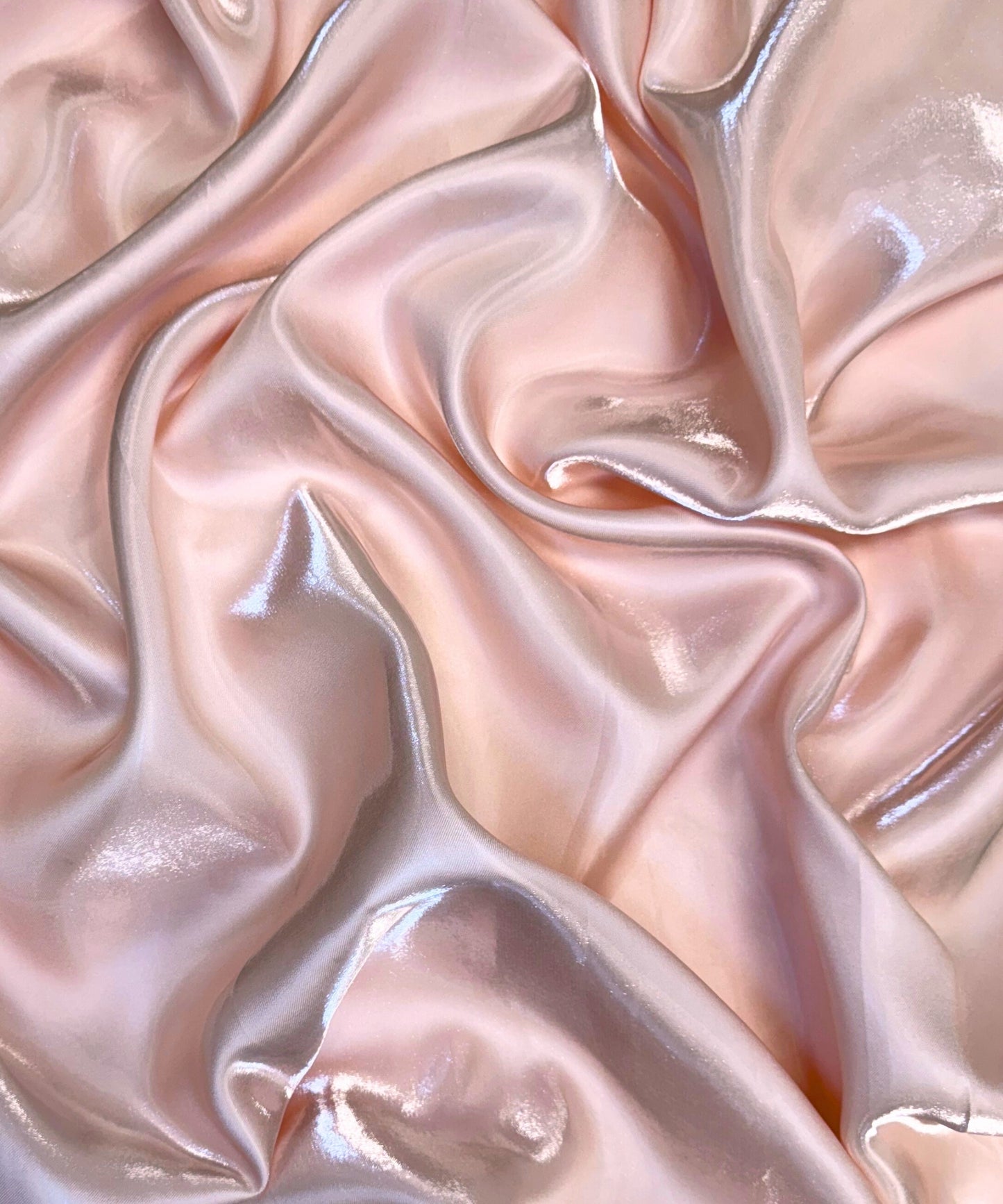 Blush liquid bridal satin fabric with ultra-glossy finish, fluid drape, and silky smooth texture – perfect for gowns and elegant décor.