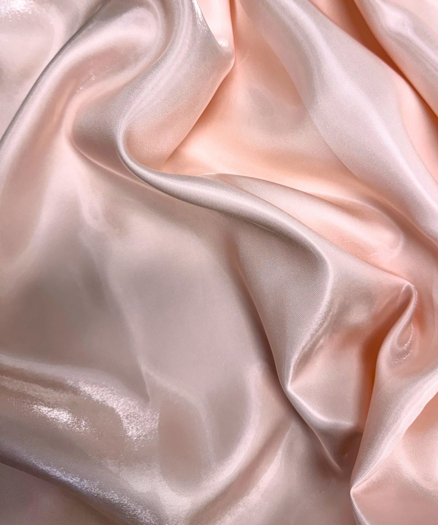 Blush liquid bridal satin fabric with ultra-glossy finish, fluid drape, and silky smooth texture – perfect for gowns and elegant décor.
