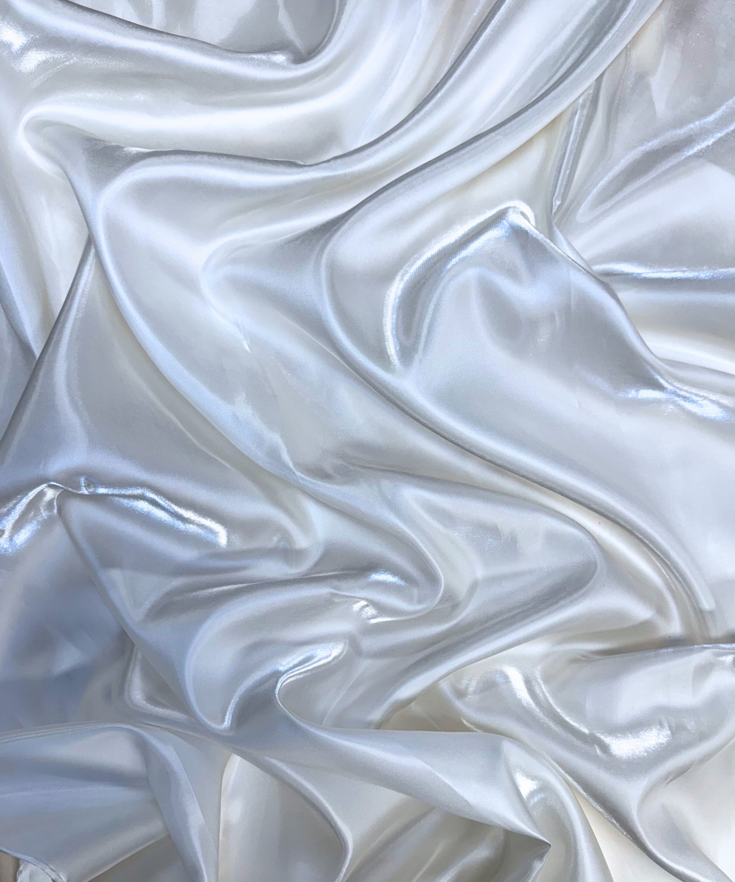 White liquid bridal satin fabric with ultra-glossy finish, fluid drape, and silky smooth texture – perfect for gowns and elegant décor.
