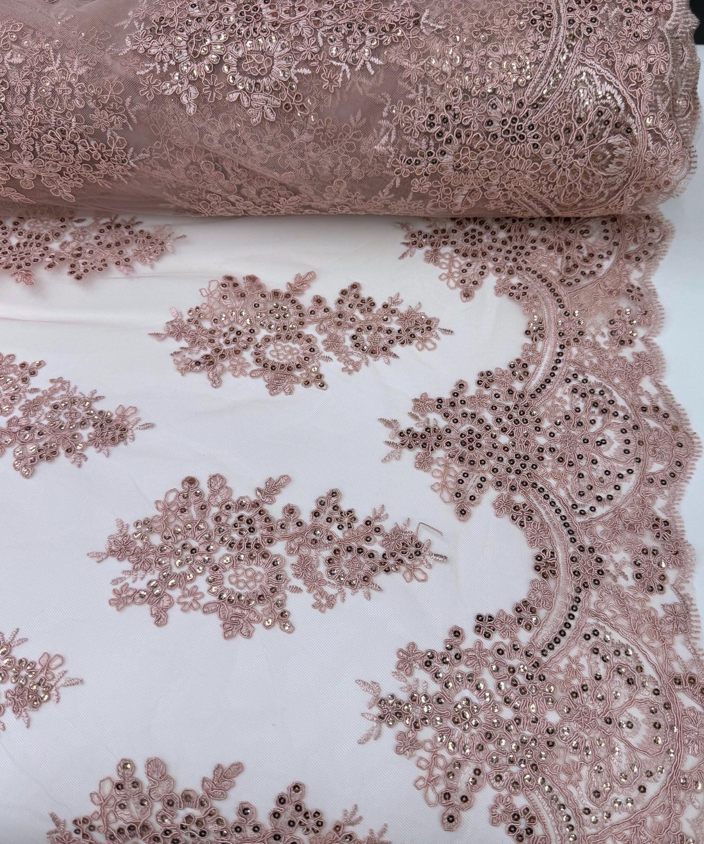 yard of dusty rose floral lace fabric with gold embroidery and sequins, detailing the intricate floral patterns and the mesh texture.