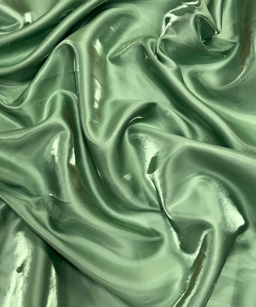 Sage green liquid bridal satin fabric with ultra-glossy finish, fluid drape, and silky smooth texture – perfect for gowns and elegant décor.