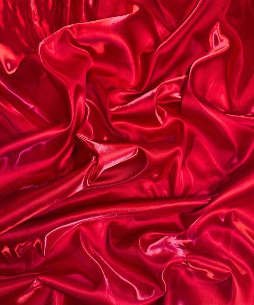 Red liquid bridal satin fabric with ultra-glossy finish, fluid drape, and silky smooth texture – perfect for gowns and elegant décor.
