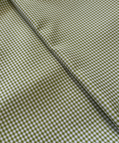 Close-up of green and white checkered fabric. Sage 1/8" Gingham Shirting Poplin