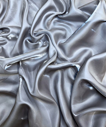 Silver liquid bridal satin fabric with ultra-glossy finish, fluid drape, and silky smooth texture – perfect for gowns and elegant décor.