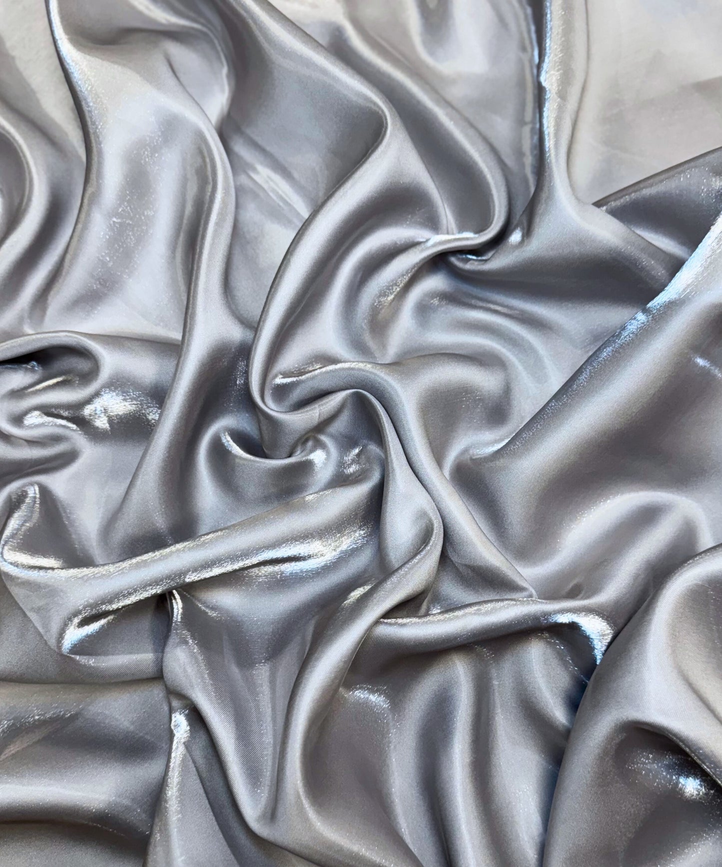 Silver liquid bridal satin fabric with ultra-glossy finish, fluid drape, and silky smooth texture – perfect for gowns and elegant décor.