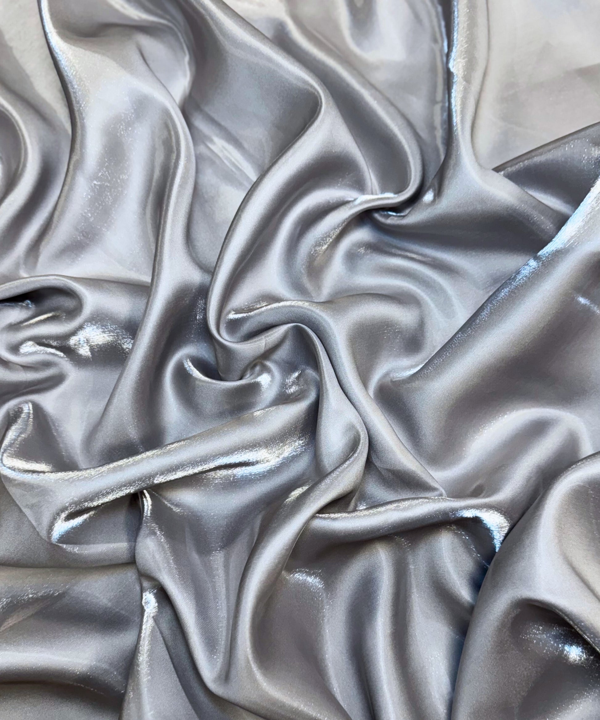 Silver liquid bridal satin fabric with ultra-glossy finish, fluid drape, and silky smooth texture – perfect for gowns and elegant décor.