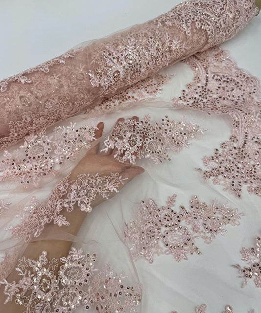 yard of blush floral lace fabric with gold embroidery and sequins, detailing the intricate floral patterns and the mesh texture.